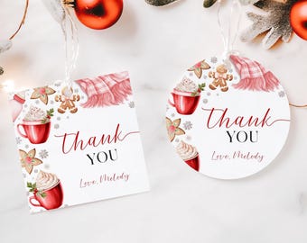 Op de afbeelding: Twee kerstcadeau-labels met een winterthema. De labels bevatten een rode mok met slagroom en een peperkoekman. De tekst op de labels luidt "Bedankt" en "Liefs, Melody".