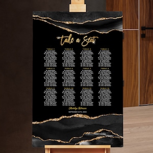 May include: Black and gold wedding seating chart with a marble-like design. The chart has the text "Take a Seat" at the top and lists tables and guest names. The bottom of the chart has the date "September 12th, 2024" and the names "Madelyn & Brennan".