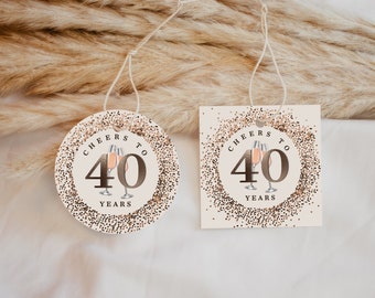 Può includere: Due etichette regalo rotonde con uno sfondo di glitter dorato e il testo "Cheers to 40 Years" con una grafica di due bicchieri di champagne.