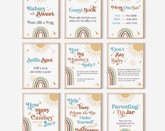 May include: Nine framed baby shower signs with a boho theme. Each sign has a white background with text in various colors, including blue, brown, and gold. The signs feature a sun and rainbow design. The text includes phrases like "Babies are Sweet" and "Guest Book."