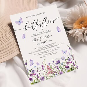Puede incluir: Una invitaci&oacute;n blanca con mariposas moradas y azules y detalles florales. El texto dice "Here's to a lifetime of butterflies" y "Please join us for a bridal shower honoring Melody Harlove". La fecha es el s&aacute;bado 20 de agosto. La invitaci&oacute;n incluye la ubicaci&oacute;n y la informaci&oacute;n de RSVP.