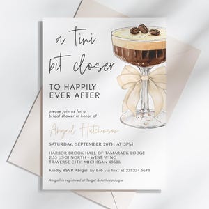 May include: A bridal shower invitation with a coffee cocktail illustration. The invitation reads "a Tini bit closer to happily ever after" and includes the bride's name, Abigail Hutchinson, the date and time of the event, and the location. The invitation also includes the text "Kindly RSVP Abigail by 8/6 via text at 231.234.5678" and "Abigail is registered at Target & Anthropologie."