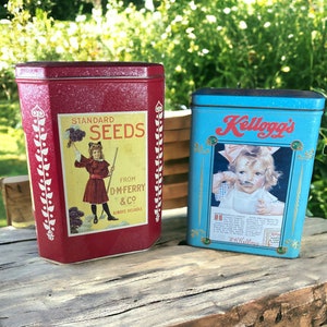 May include: Two vintage tin boxes. The red box has a white label with the text "Standard Seeds from D.M. Ferry & Co. Always Reliable". The blue box has a white label with the text "Kellogg's" and a picture of a young girl eating cereal.