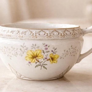 May include: A set of three ceramic mugs with a speckled, matte finish. The mugs are in shades of cream, light gray, and dark gray. Each mug has a simple, minimalist design and a rounded handle.