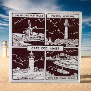 May include: A vintage ceramic tile with four illustrations of Cape Cod landmarks. The top left image shows a windmill with the text "One of the Old Mills". The top right image shows a tower with the text "Pilgrim Memorial". The bottom left image shows a lighthouse with the text "Chatham Light". The bottom right image shows a bridge with the text "Cape Cod Canal Bridge". The tile has the text "Cape Cod, Mass." in the center.