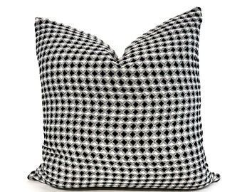 Könnte beinhalten: Schwarzes und weißes geometrisches Kissen mit Muster. Das Kissen hat ein quadratisches Muster mit einer dezenten, erhabenen Textur.