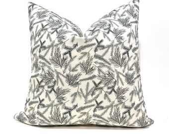 May include: A white throw pillow with a black and green pine needle pattern.