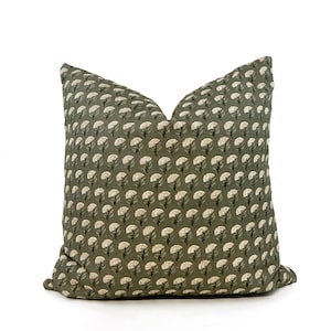 May include: A green throw pillow with a white floral pattern. The pillow is made of a soft, textured fabric.