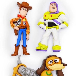 May include: Three toy character buttons featuring Woody, Buzz Lightyear, and Slinky Dog from the Toy Story franchise. The buttons are made of colorful plastic and are approximately 2 inches tall.