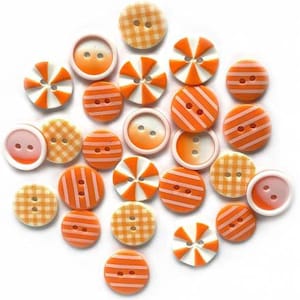 May include: A collection of 20 orange and white buttons with various patterns, including stripes, polka dots, and gingham. The buttons are made of plastic and have a smooth finish.