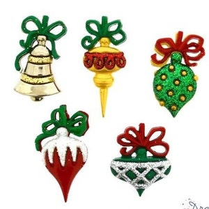 May include: Five Christmas ornaments with green, red, and gold glitter. The ornaments are shaped like a bell, a teardrop, and a round ball. The ornaments have green, red, and gold bows.