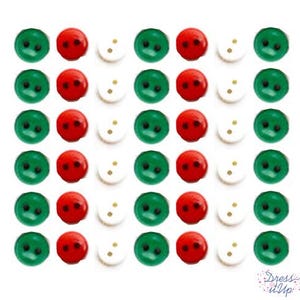 May include: A collection of small, round buttons in a repeating pattern. The buttons are in three colors: green, red, and white. Each button has two holes. The image is on a white background. The text "Dress it Up" is in the bottom right corner.