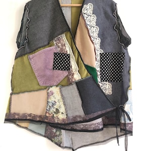 Puede incluir: Un chaleco patchwork con una variedad de telas, incluyendo mezclilla, pana y estampados florales. El chaleco presenta ribete de encaje, detalles de lunares y cierre de lazo. Los colores incluyen gris, verde, morado y beige.