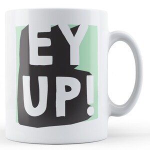May include: White ceramic mug with a green and black graphic that says "EY UP!"
