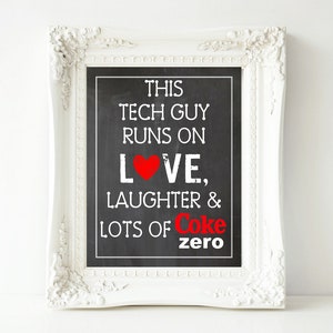 May include: White framed chalkboard sign with the text "This Tech Guy Runs On Love, Laughter & Lots of Coke Zero" in black and red lettering. A red heart is included in the word "Love".