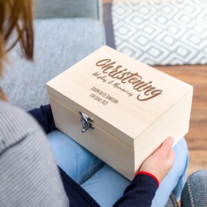 May include: A wooden box with a hinged lid and a metal clasp. The box is engraved with the words "Christening Wishes & Memories", "Joseph Alfie Townson", and "6th June 2021".