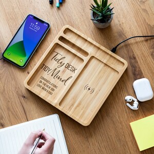 May include: A wooden desk organiser with a wireless charging pad, two compartments, and the text "Tidy Desk Tidy Mind Congratulations on the new job! Love Mum & Dad" engraved on the surface.