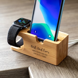 May include: A wooden phone and smartwatch charging stand with a personalised message that reads "Best Dad Ever Happy Father's Day 2020 Love Chloe & Thomas".