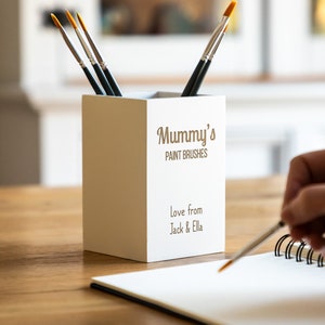 May include: White ceramic paintbrush holder with the text "Mummy's Paint Brushes" and "Love from Jack & Ella".