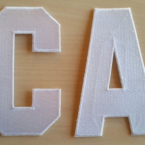 May include: White felt letters spelling out the word "CA".