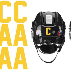 May include: Black hockey helmets with yellow "C" and "A" letters, along with several yellow "C" and "A" letters. The helmets have a chin strap and various stickers.