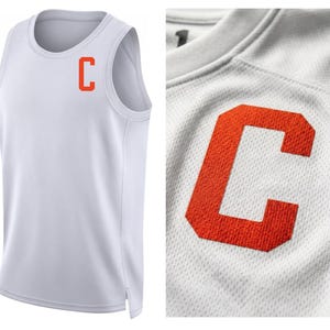 May include: White athletic tank top with an orange "C" logo on the chest. The tank top has a round neckline and a sleeveless design. The fabric has a textured, breathable appearance, suitable for sports and physical activity.