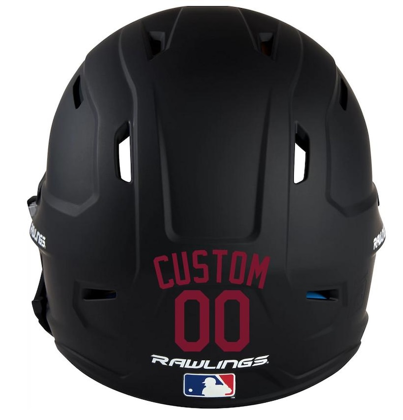 May include: Black baseball helmet with the word "CUSTOM" and the number "00" in maroon. The Rawlings logo and MLB logo are visible at the bottom. The helmet has several vents and is designed for protection.