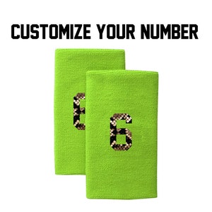 Peut inclure: Deux bandeaux de transpiration vert lime avec un numéro 6 imprimé en texture peau de serpent sur chacun. Personnalisez votre numéro.