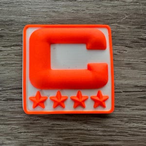May include: Orange and white patch with a large capital letter "C" and four white stars below it.
