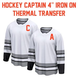 May include: Two white hockey jerseys with black sleeves and gray stripes. One jersey has a large orange "C" and the other has an orange "A". The text "HOCKEY CAPTAIN 4" IRON ON THERMAL TRANSFER" is at the top.