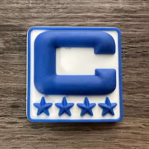 May include: Blue and white patch with a large capital C in the center and four stars below. The patch is made of a rubber-like material.
