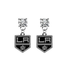 May include: A pair of silver-toned earrings. Each earring features a clear, round gemstone at the top, connected to a shield-shaped charm. The charm displays the letters "LA" in white, with a crown at the bottom, set against a black background.