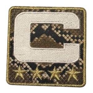 Puede incluir: Parche cuadrado con un fondo de patr&oacute;n de piel de serpiente y una letra "C" blanca bordada. Debajo de la letra hay cuatro adornos dorados en forma de estrella. El parche tiene un borde dorado.
