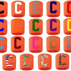 May include: Twenty-four orange wristbands with a white letter "C" in various colors and patterns, including black, white, blue, green, orange, yellow, pink, brown, gray, glitter, camouflage, American flag, and snake skin.