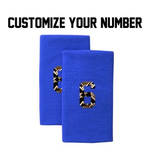Peut inclure: Deux bandeaux de transpiration bleu royal avec un numéro six en peau de serpent dorée et noire sur chacun.
