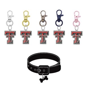 May include: Five different colored dog tags with a red and black Texas Tech University logo. The dog tags are attached to a black dog collar with a bone charm.