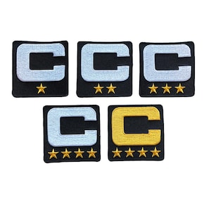 May include: Five embroidered patches featuring a capital letter "C" in various colors. The patches are square with a black background and gold stars below the letter. The "C" is either light blue or gold.
