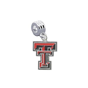 Puede incluir: Un charm plateado con un logotipo de la Universidad Tecnológica de Texas en rojo y negro. El charm está diseñado para encajar en una pulsera o un collar.