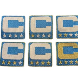 May include: Six embroidered patches with a light blue background and a white "C" design. Each patch has a gold border and five gold stars at the bottom. One patch has a gold "C".
