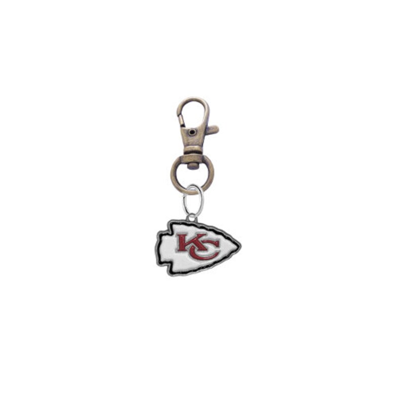 May include: A silver and gold keychain with a white arrowhead charm featuring the Kansas City Chiefs logo in red and white.