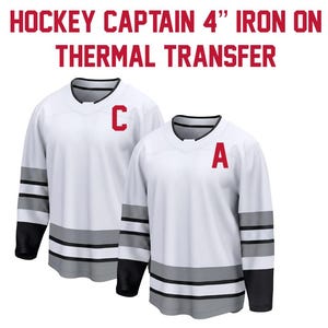 May include: Two white hockey jerseys with black and gray accents. One jersey has a red "C" and the other has a red "A". The text "HOCKEY CAPTAIN 4" IRON ON THERMAL TRANSFER" is at the top.