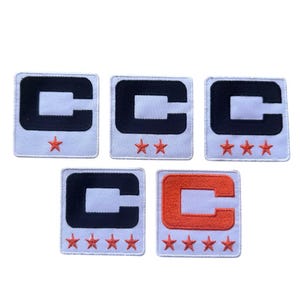 May include: Five square patches with a white background. Each patch features a black or orange letter "C" and a varying number of orange stars. The patches are likely for clothing or accessories.
