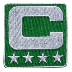 Peut inclure: Écusson brodé vert et blanc. Il présente un grand « C » blanc dans un carré vert, avec quatre étoiles blanches en dessous. L'écusson est bordé de blanc.