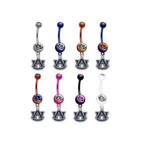 May include: A set of eight belly button rings with a variety of colored metal bars and crystal accents. Each ring features a charm with the Auburn University logo.