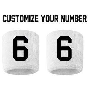 May include: Two white wristbands with black numbers "6" printed on them. Customize Your Number.
