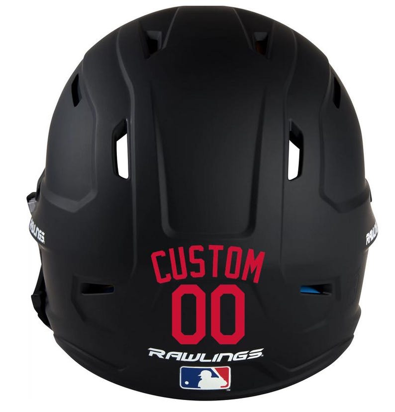 May include: Black baseball helmet with the word "CUSTOM" and the number "00" in red. The Rawlings logo and a Major League Baseball logo are also visible.