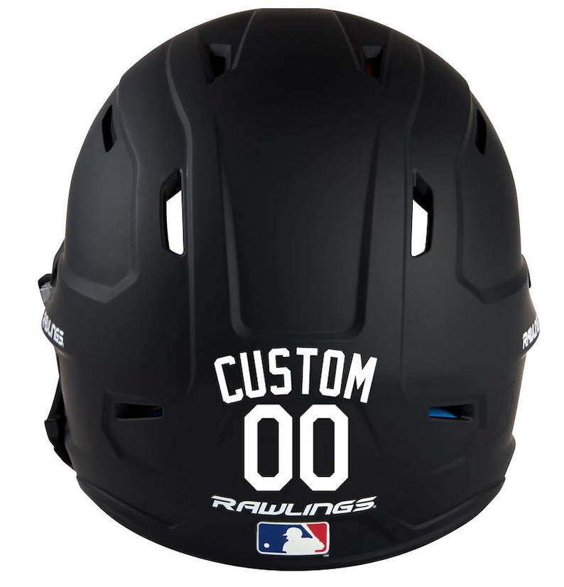 May include: A black baseball helmet with the word "CUSTOM" and the number "00" in white lettering. The Rawlings logo and MLB logo are also visible. The helmet is designed for protection during baseball games.