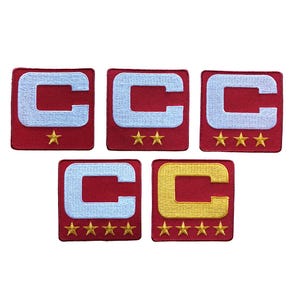 May include: Five red embroidered patches featuring a white letter "C" with a star or stars below. One patch has a gold "C" and gold stars. The patches are square and have a red border.