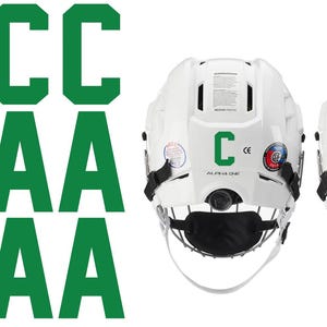 May include: White hockey helmets with black face masks and green letter decals. One helmet has a green "C" and the other has a green "A". The image also shows multiple green "C" and "A" decals.