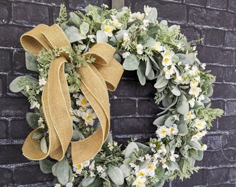 Corona de primavera con forma de orejas de cordero: flores blancas y lazo de arpillera